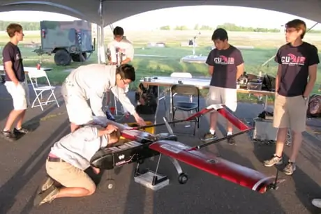 The CUAir team balances their plane's center of gravity in preparation for their early-morning mission flight during the competition.