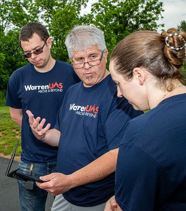 Peter Miller (center) reviews pre-flight checklist built into Wingtra Pilot interface with 2nd-year students Amanda Moberg and John Merrill.