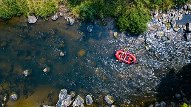 Aerial view, Sportman team are rafting on the river turbulent flow. Extreme and enjoyment sport.