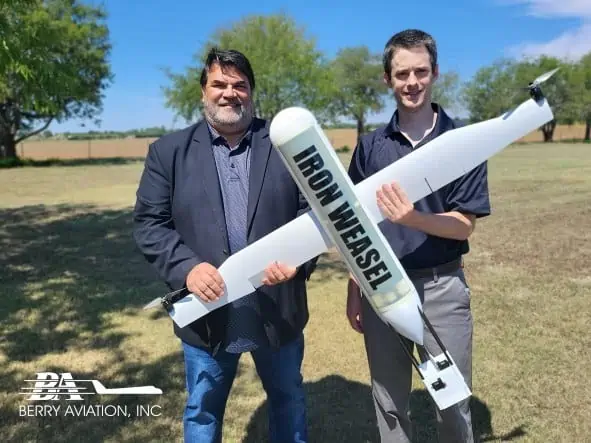 Berry Aviation Vice President of Unmanned Autonomous Systems, Rick Gaeta, (left) and Berry Aviation engineer, Brian Delano, display an example of the company’s Iron Weasel, an autonomous vehicle designed for use in the Group 1 UAS Air-Launched Effector market.