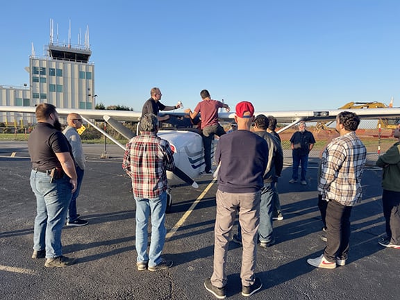 WarrenUAS students watch the pre-flight check of a manned aircraft to gain a better understanding and appreciation of the aviation safety culture that is shared in the professional drone industry.